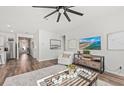 Bright living room with wood floors, ceiling fan, modern decor, and an open layout to the kitchen at 782 Meadowbrook Ln, Summerville, SC 29486