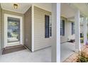 Inviting front porch with pillars and exterior door with glass, sheltered from the elements at 8612 Hickory Creek Ln, North Charleston, SC 29420