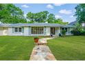 Charming home featuring a stone walkway, well-manicured lawn, and mature trees in a sunny setting at 881 Evans Rd, Charleston, SC 29412