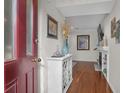 Welcoming foyer with bright lighting, white cabinet, elegant decor, and hardwood floors at 1050 Marsh Court Ln, Mount Pleasant, SC 29464