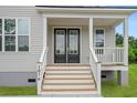Charming front porch with black double doors and wooden stairs at 1076 Williams Rd, Charleston, SC 29412