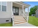Inviting front porch with wooden stairs and white railings leading to the home's entrance at 1076 Williams Rd, Charleston, SC 29412