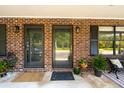 Cozy front porch with a brick facade, decorative plants, and comfortable seating at 1166 Julian Clark Rd, Charleston, SC 29412