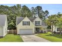 Inviting two-story home featuring lush green lawn and welcoming front porch with white railings at 172 Cotillion Cresent Cres, Summerville, SC 29483