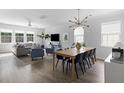 Open-concept living and dining area with modern lighting, sleek wood floors, and bright, airy atmosphere at 1825 Crossbill Trl, Hanahan, SC 29410