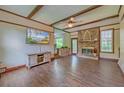 Inviting living room showcasing a brick fireplace, wood-beamed ceiling, and wood-style flooring at 202 Hunt Club Dr, Summerville, SC 29485