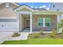 Charming home with a brick facade, covered entrance, and well-maintained landscaping at 206 Camellia Bloom Dr, Moncks Corner, SC 29461