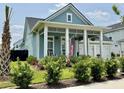 Inviting home showcasing blue siding, white trim, a welcoming front porch with rocking chairs, and a two-car garage at 2221 Generals St, Charleston, SC 29492