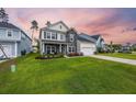 Attractive two-story home with stone and siding exterior, lush green lawn, and inviting curb appeal at 223 Granton Edge Ln, Summerville, SC 29486