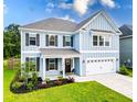 Charming two-story home with blue siding, shutters, a well-kept lawn, and an attached garage at 256 Fiddleback Dr, Summerville, SC 29486