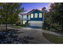 Charming blue two-story home at twilight with a spacious driveway and welcoming double porch at 3306 Hartwell St, Johns Island, SC 29455