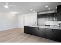 Modern kitchen with stainless steel appliances, dark cabinets, island with quartz countertop, hardwood floors and recessed lights at 331 Bremerton Dr, Goose Creek, SC 29445