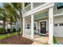 Inviting front porch with white railings, and a cozy seating area at 415 True North Trail, Summerville, SC 29486