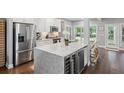 Bright, modern kitchen with stainless steel appliances, marble counters, and wine fridge at 5195 Forest Oaks Dr, Hollywood, SC 29449