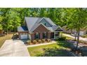 Inviting brick home with lush lawn and an attached garage, surrounded by beautiful trees offering shade and serenity at 5442 Clearview Dr, North Charleston, SC 29420
