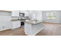Modern kitchen featuring white cabinets, granite countertops, stainless steel appliances, and a center island at 5516 Bowmore Blvd, Ravenel, SC 29470