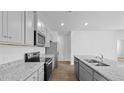 Contemporary kitchen with gray cabinets, granite countertops, stainless appliances, and a large island with a sink at 6039 Savy Ct, Ravenel, SC 29470