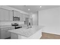 Modern kitchen featuring gray cabinets, stainless steel appliances, granite countertops, and a large island at 6039 Savy Ct, Ravenel, SC 29470
