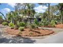 Inviting exterior with mature landscaping providing shade, surrounded by mulch and greenery at 622 E Cooper Ave, Folly Beach, SC 29439