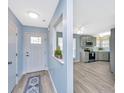 Inviting foyer features gray-blue walls, wood-look floors, with a view to the updated kitchen at 8507 William Moultrie Dr, North Charleston, SC 29420