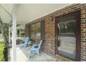 A charming front porch view with brick accent wall, blue chairs, and an inviting front door at 925 Dills Bluff Rd # 34, Charleston, SC 29412