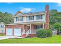 Charming two-story home with a brick facade, inviting front porch, a two-car garage and well-maintained lawn at 100 Cicero Ct, Goose Creek, SC 29445