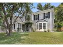 Stylish two-story home features gray siding, black shutters, a bay window, and a well-maintained lawn at 100 Conset Bay Ct, Goose Creek, SC 29445