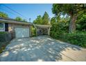 Driveway and backyard featuring a detached garage and large trees providing shade at 100 S Gum St, Summerville, SC 29483