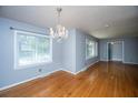 Dining room with hardwood floors, gray paint, chandelier, and multiple windows at 100 S Gum St, Summerville, SC 29483