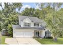 Charming two-story home with a two-car garage, a well-manicured lawn, and beautiful trees providing shade at 103 Trimley Ct, Goose Creek, SC 29445