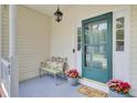 Inviting front porch with a cozy bench, decorative pillows, and charming flower pots welcoming visitors at 103 Trimley Ct, Goose Creek, SC 29445