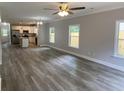 Open-concept living space with wood-look floors and views of the kitchen with stainless steel appliances at 110A Dukes St, Saint George, SC 29477
