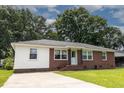 Charming brick and vinyl ranch-style home with a well-manicured lawn and mature trees creating a serene atmosphere at 116 Lyle Rd, Goose Creek, SC 29445