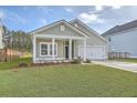 Charming single-Gathering home with a well-manicured lawn, attached garage, and inviting front porch with white pillars at 117 Oyster Tide Ave, Summerville, SC 29485