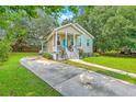 Quaint home with a long driveway and lush green lawn, framed by mature trees, exuding curb appeal at 1338 Addykay Pl, North Charleston, SC 29406