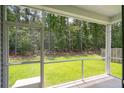 View from screened porch reveals serene, wooded backyard views at 139 Sunray Ln, Summerville, SC 29486
