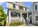 Inviting front porch with white railings, ceiling fan, and shuttered windows at 1615 Paradise Lake Dr, Mount Pleasant, SC 29464
