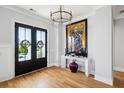 Welcoming foyer with hardwood floors, art and double doors with wreaths on them at 1714 Fort Palmetto Cir, Mount Pleasant, SC 29466