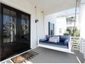 Inviting porch with a comfortable swing and decorative wreaths on double front doors of the home at 1714 Fort Palmetto Cir, Mount Pleasant, SC 29466