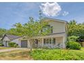 Attractive two-story home with a covered front porch, attached garage, and lush lawn at 1743 Orange Grove Shores Dr, Charleston, SC 29407
