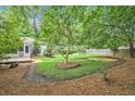 Private backyard with a small deck, mature trees, and a wooden fence at 1833 St Julian Dr, Charleston, SC 29407