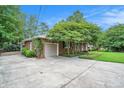View of the home with an attached garage and concrete driveway surrounded by greenery at 1833 St Julian Dr, Charleston, SC 29407