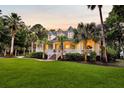 Charming home featuring a classic white porch, red brick steps, and beautifully landscaped yard with palm trees at 2040 Shell Ring Cir, Mount Pleasant, SC 29466