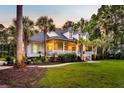 Beautiful home features a long front porch, dormer windows, lush landscaping, and mature trees at 2040 Shell Ring Cir, Mount Pleasant, SC 29466
