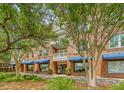 Brick building with blue awnings, mature trees, and landscaped walkway at 260 Seven Farms Dr # 306, Charleston, SC 29492