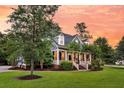 A charming two-story home shows a beautifully landscaped yard and inviting front porch at 2720 Oak Manor Dr, Mount Pleasant, SC 29466