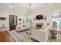 Bright living room with fireplace, large rug, stylish sofas, and elegant chandelier perfect for entertaining guests at 28 Robert Mills Cir, Mount Pleasant, SC 29464