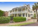Charming yellow two-story home with a double veranda and lush green landscaping at 29 Smith St, Charleston, SC 29401