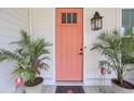 Inviting front entry featuring a vibrant orange door, elegant lantern, and decorative potted plants at 351 Gnarly Oak Ln, Summerville, SC 29485