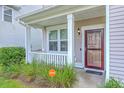 Cozy front porch with white columns, lovely landscaping and a security system sign at 531 Crossland Dr, Moncks Corner, SC 29461